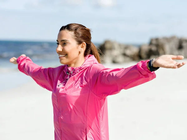 Mujer atlética en ropa deportiva de pie en la playa —  Fotos de Stock