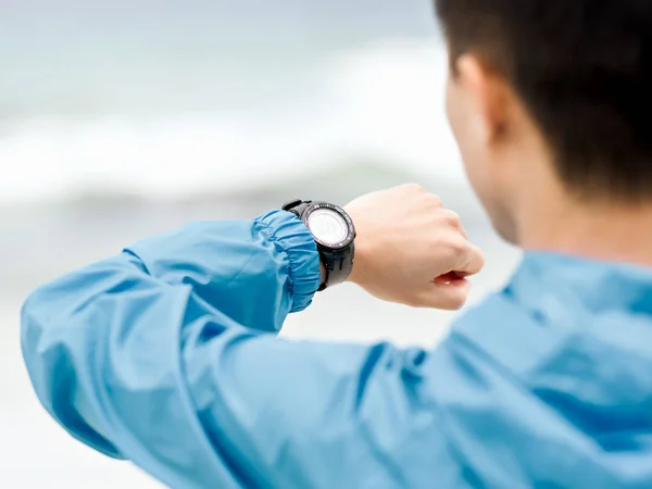 Joven en ropa deportiva usando smartwatch —  Fotos de Stock