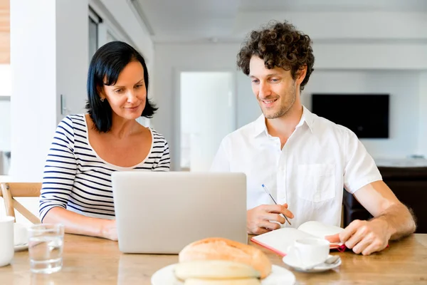 Felice coppia moderna che lavora sul computer portatile a casa — Foto Stock