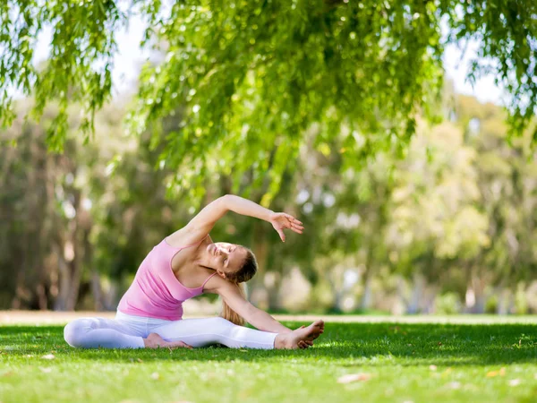 Parkta yoga yapan genç kadın. — Stok fotoğraf