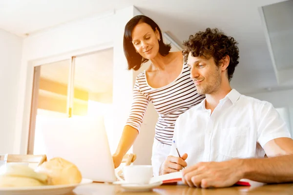 Feliz pareja moderna trabajando en el ordenador portátil en casa —  Fotos de Stock