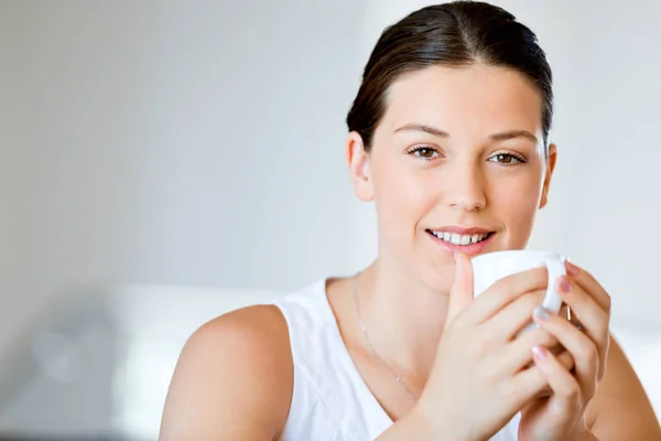 Mujer joven feliz con taza de té o café en casa — Foto de Stock