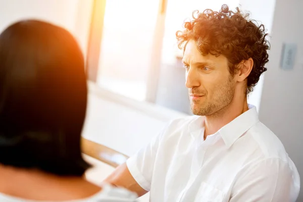 Portrait of man sitting and talking to woman indoors — Stock Photo, Image