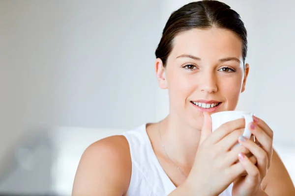 Щаслива молода жінка з чашкою чаю або кави вдома — стокове фото
