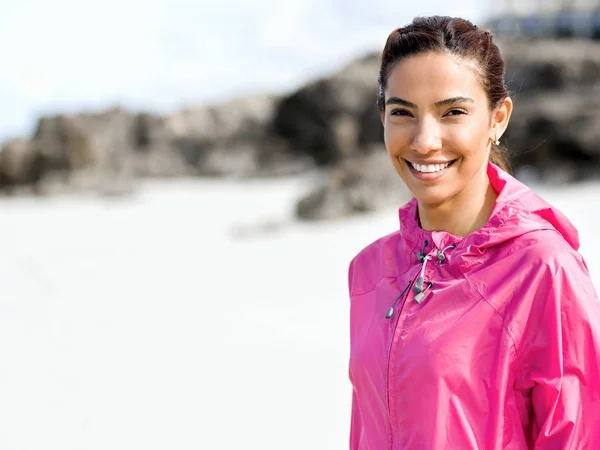 Sportieve vrouw in sportkleding staande aan de kust — Stockfoto