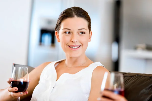 Kırmızı şarap ile cam tutan güzel genç kadın — Stok fotoğraf