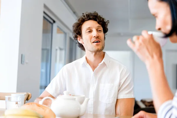 Portrait of man sitting and talking to woman indoors — Stock Photo, Image