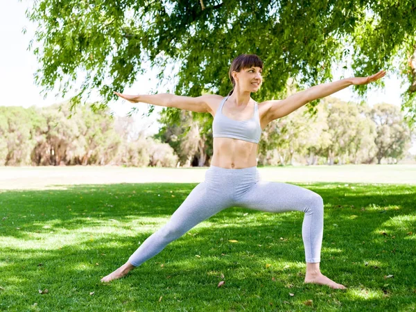 Młoda kobieta praktykująca jogę w parku — Zdjęcie stockowe