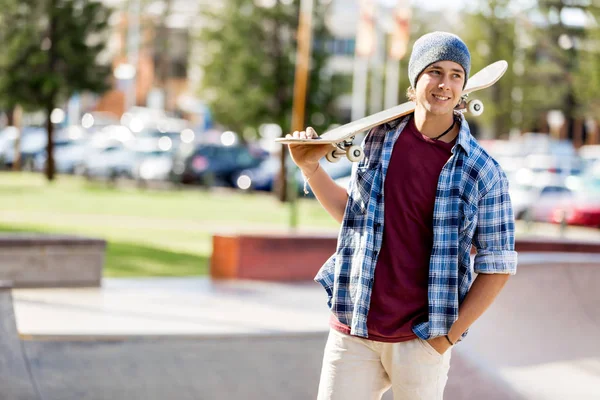 Adolescente con monopatín de pie al aire libre — Foto de Stock