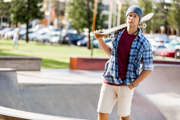 Adolescent garçon avec skateboard debout à l'extérieur Images De Stock Libres De Droits