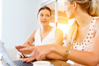 Birlikte laptop çalışan iki genç kadın