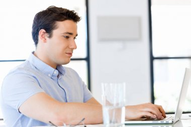 Bilgisayarda çalışan yakışıklı işadamı