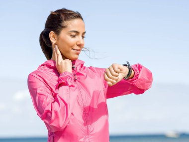 Genç kadın plajda çalıştırdıktan sonra nabız kontrol