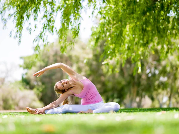 Parkta yoga yapan genç kadın. — Stok fotoğraf