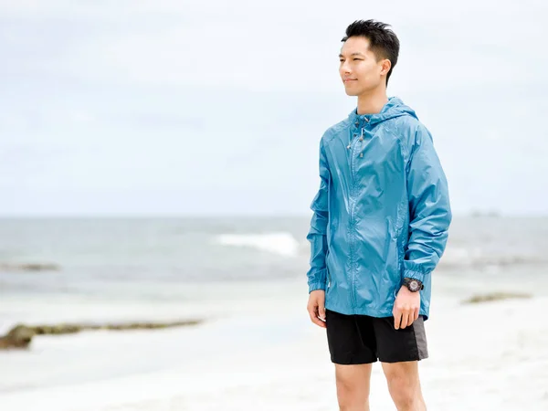 Jonge man staande op het strand — Stockfoto