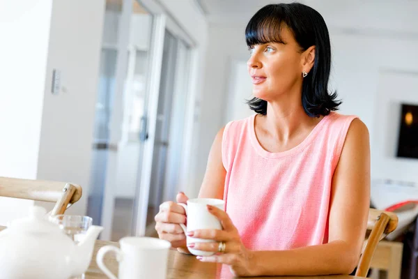 Boldog asszony csésze tea vagy kávé otthon — Stock Fotó