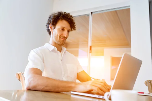 Mann arbeitet zu Hause am Laptop — Stockfoto