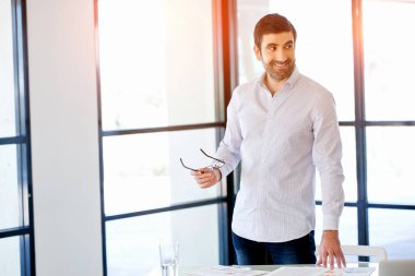 Ofiste duran genç beyaz iş adamı