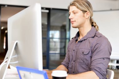 Bilgisayarda çalışan yakışıklı işadamı