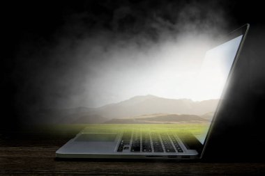 Koyu arka plan açılan laptop. Karışık teknik