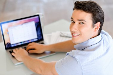 Bilgisayarda çalışan yakışıklı işadamı