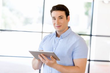 Genç yakışıklı işadamı onun touchpad ayakta kullanma office