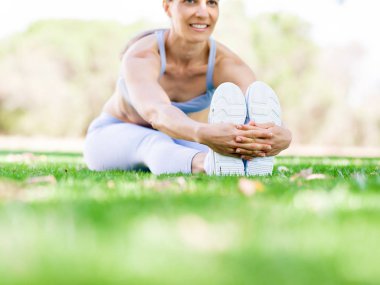 Parkta egzersiz yapan genç bir kadın.