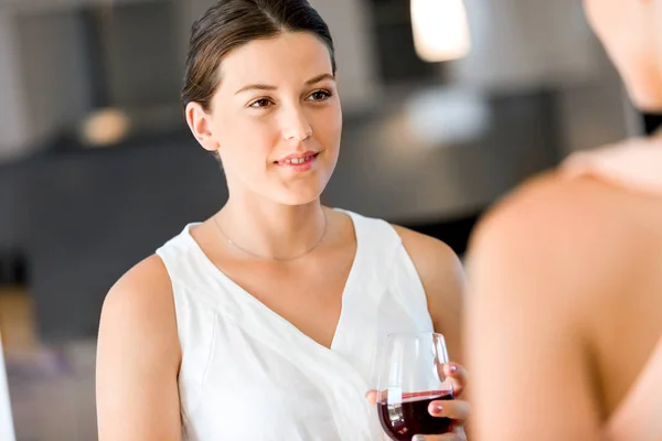 Fiatal nő barátja egy pohár bor bent tartja — Stock Fotó
