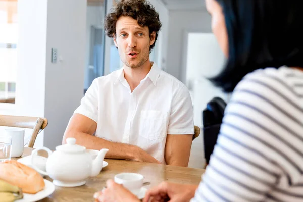 Portrait of man sitting and talking to woman indoors — Stock Photo, Image