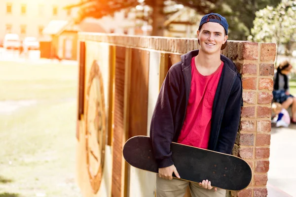 Teenage boy with skateboard standing outdoors — Stock Photo, Image