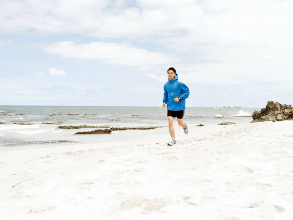 Junger Mann läuft am Meer entlang — Stockfoto