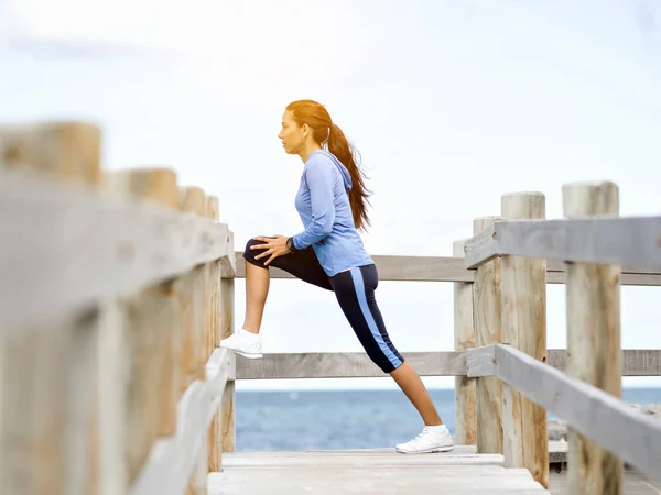 Junge Frau am Strand macht Übungen — Stockfoto