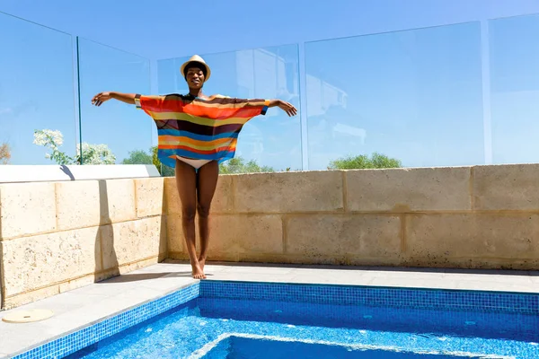 Mujer joven de pie junto a la piscina —  Fotos de Stock