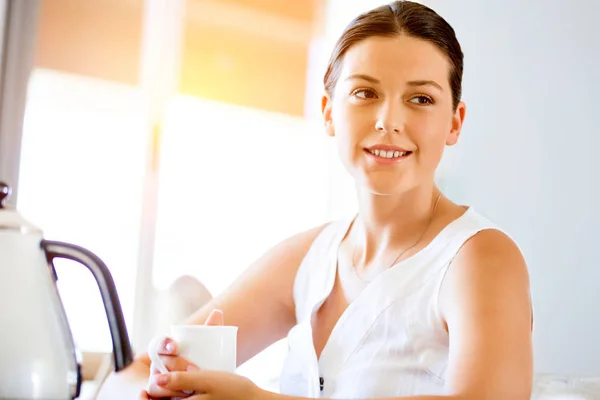 Mujer joven feliz con taza de té o café en casa —  Fotos de Stock