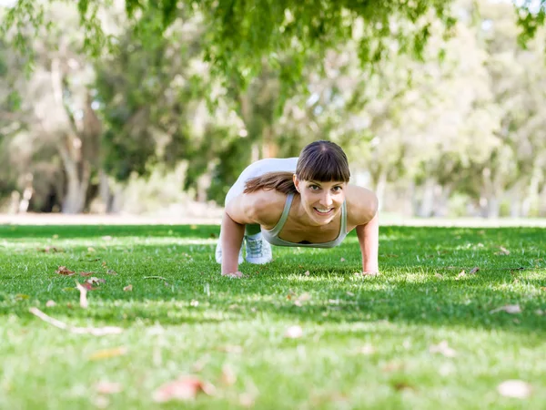 Parkta egzersiz yapan genç bir kadın. — Stok fotoğraf