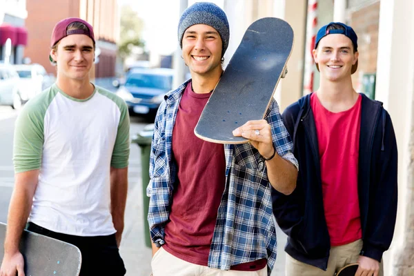 Adolescentes amigos andando na rua com skates — Fotografia de Stock