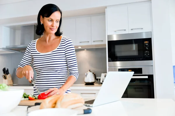 Mulher bonita de pé na cozinha e cozinhar — Fotografia de Stock