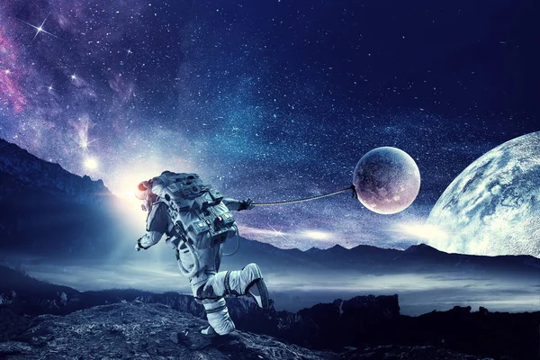 Fantasie-Bild mit Raumfahrer fangen Planeten. Gemischte Medien — Stockfoto