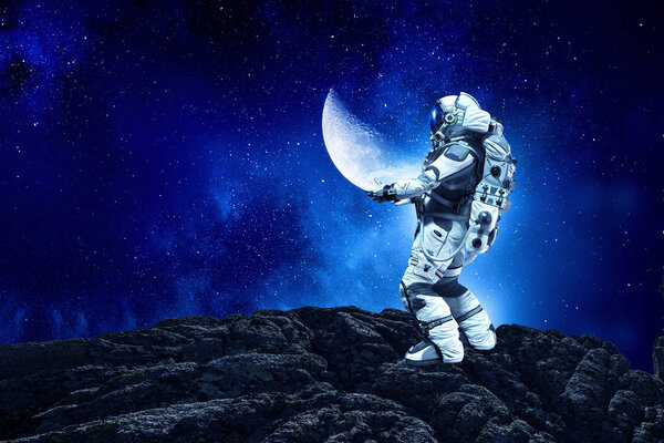Astronaut holding moon planet in hands. Elements of this image furnished by NASA.