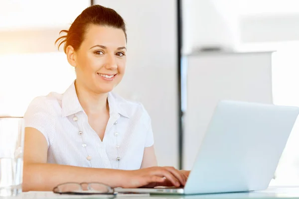 Porträt einer Geschäftsfrau, die im Büro am Computer arbeitet — Stockfoto