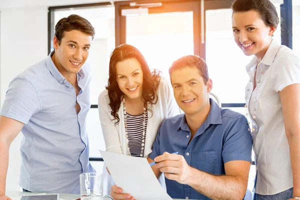 Groep van gelukkige jonge zakenmensen in een vergadering — Stockfoto