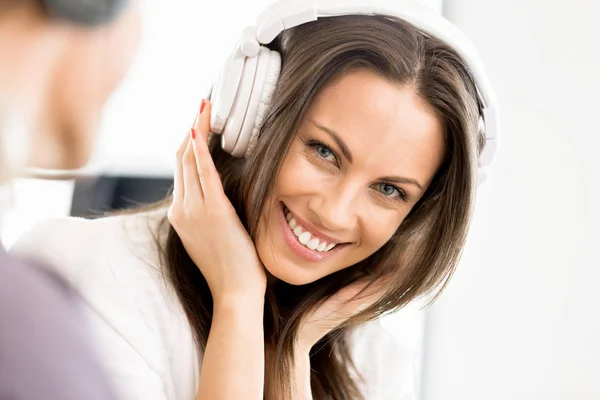 Young woman in the office with headphones — Stock Photo, Image