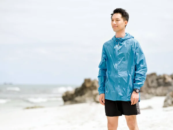 Jonge man staande op het strand — Stockfoto