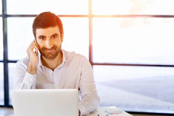 Sebevědomý mladý muž v smart casual oblečení drží telefon — Stock fotografie