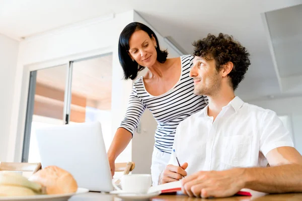 Felice coppia moderna che lavora sul computer portatile a casa — Foto Stock