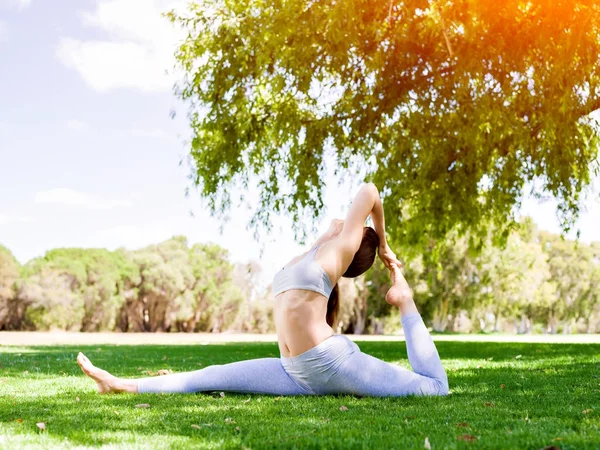 Genç kadın parkta yoga yapıyor. — Stok fotoğraf