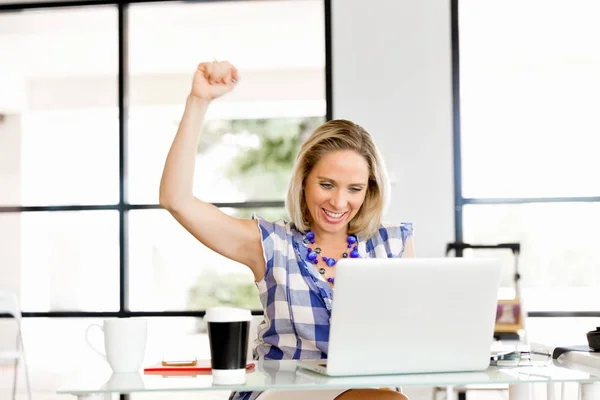 Uma jovem no escritório celebrando o sucesso — Fotografia de Stock