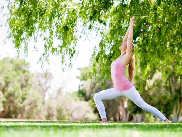 Mujer joven haciendo yoga en el parque — Foto de Stock