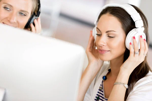 Mujer joven con auriculares en el interior — Foto de Stock