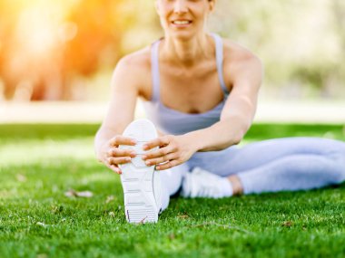 Parkta egzersiz yapan genç bir kadın.